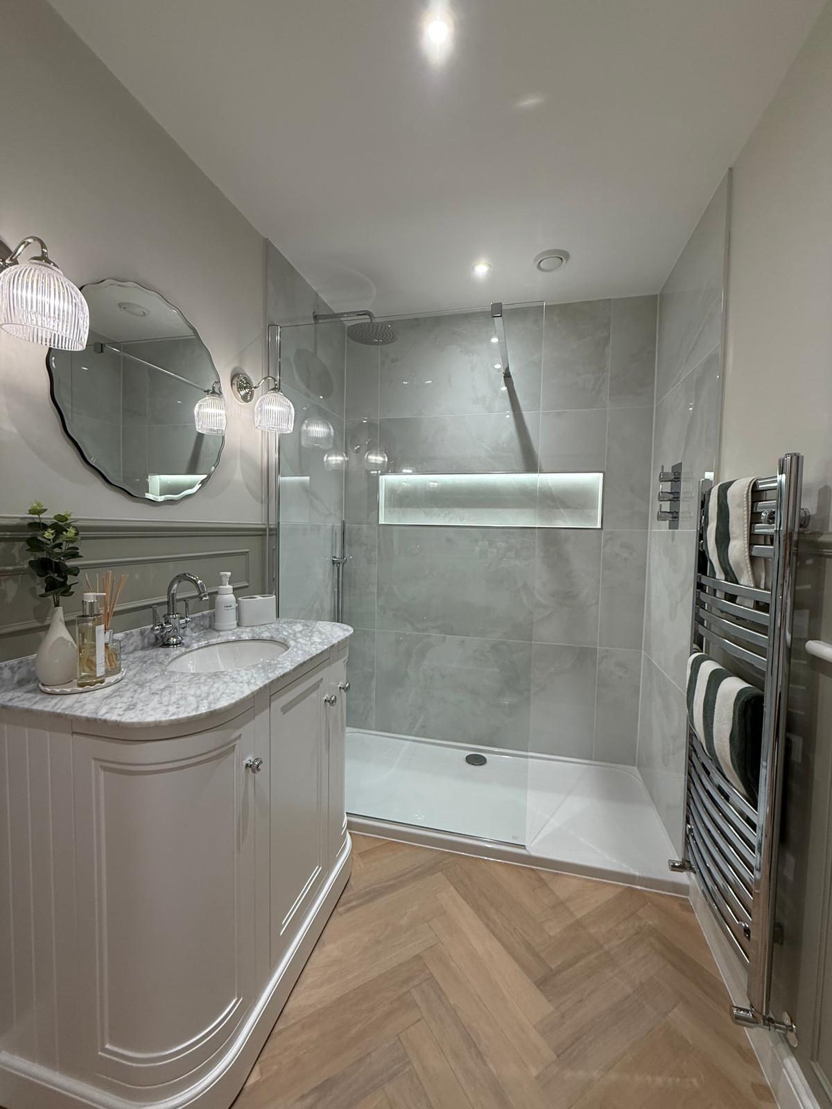 Luxury walk-in shower bathroom installation with illuminated niche and bespoke vanity