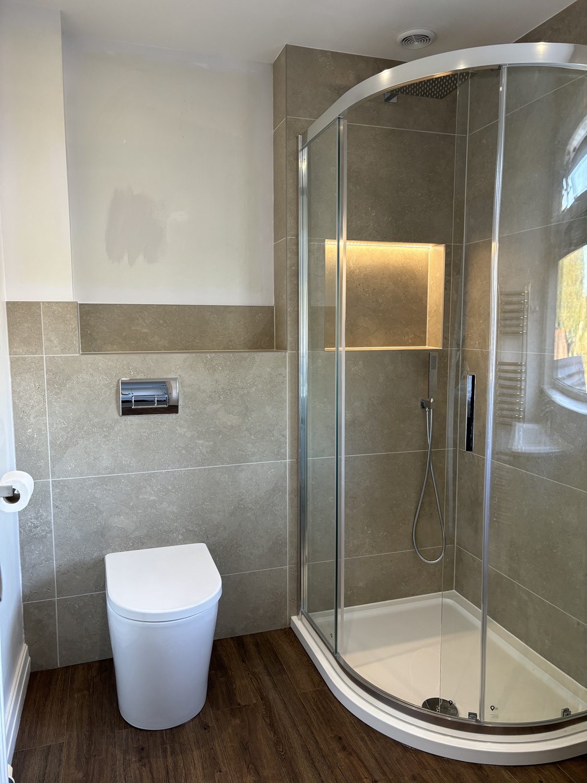 Quadrant shower and wall-hung toilet in grey bathroom