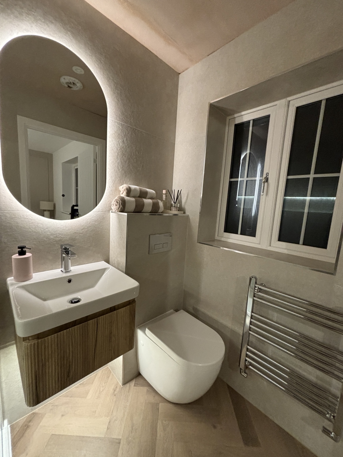 Warm neutral cloakroom with illuminated mirror